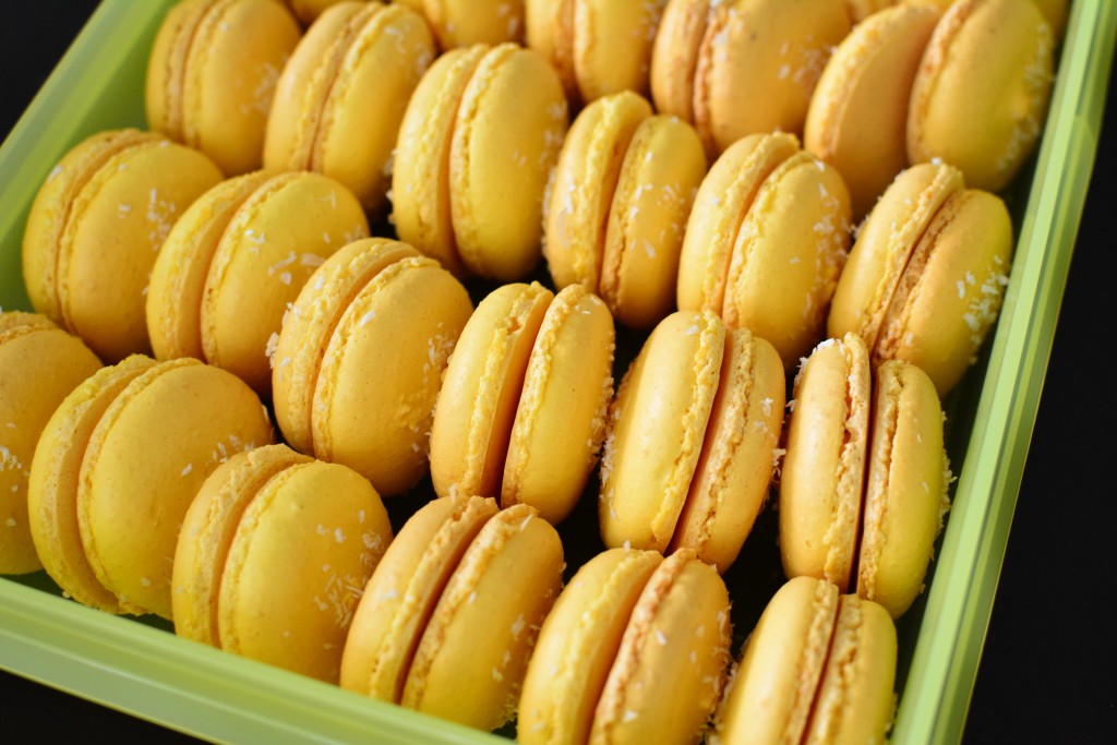 Yellow macaron shells with dessicated coconut